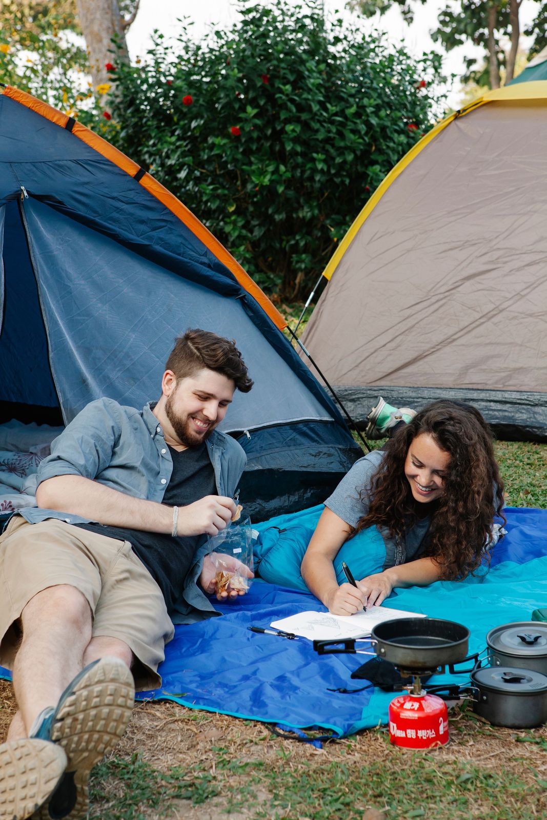 Rectangular camp sleeping bag spread out at a campsite
